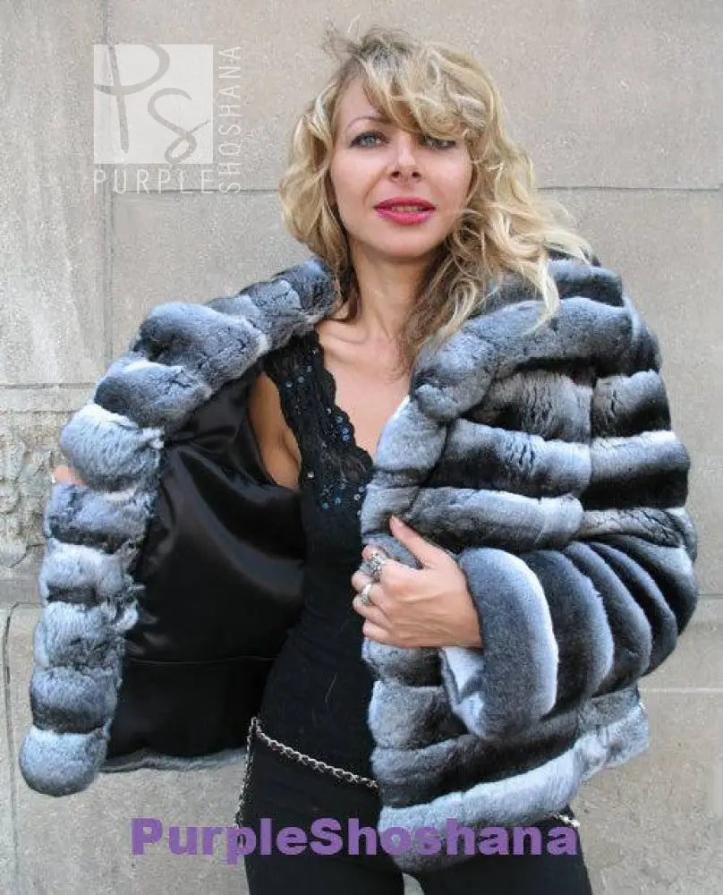 Hooded dark gray fur jacket worn over black top, open front