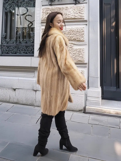 Beige mink fur coat with pointed collar, side profile and long sleeves.