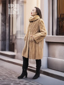 Beige mink fur coat from the side, stand collar and long sleeves visible.