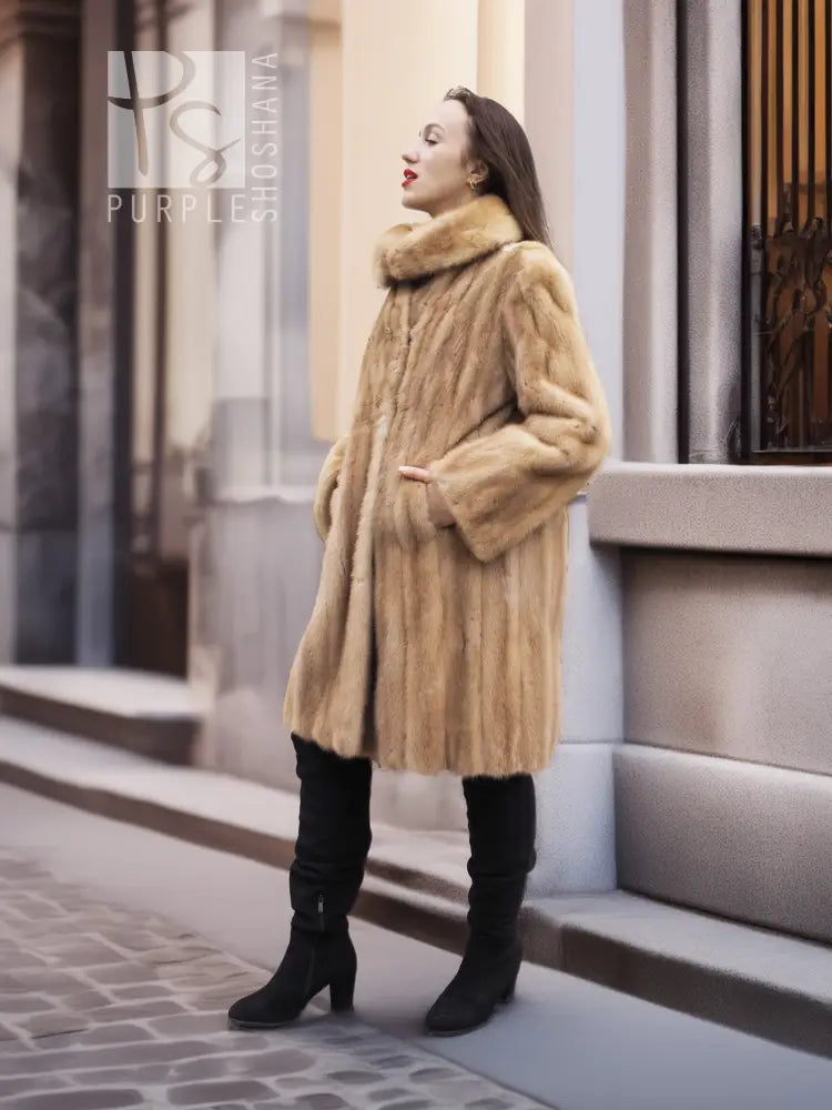 Beige mink fur coat from the side, stand collar and long sleeves visible.