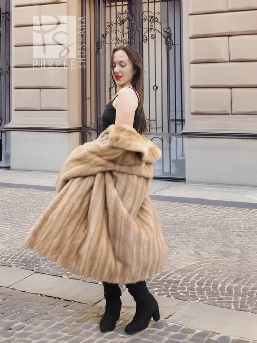Beige mink fur coat with stand collar and button front; back view with full flared hem.