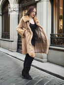 Beige mink fur coat with plush collar, open front over a black dress and boots.