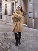 Beige mink fur coat with button front and high collar; full-length sleeves visible.