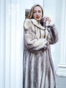 Hooded mink fur coat with cross-stripe pattern and front closure, close-up view.