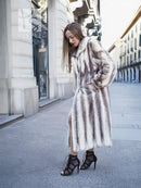 Mink fur hooded coat with thick fur texture, side view with one hand near pocket