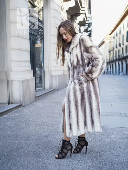Mink fur hooded coat with thick fur texture, side view with one hand near pocket