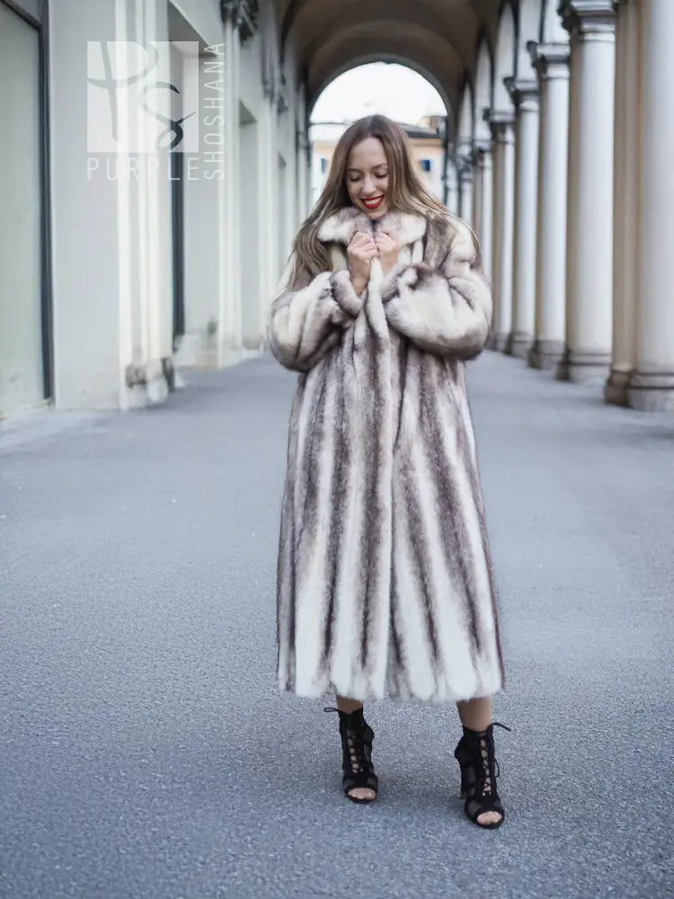 Long hooded mink fur coat with cross-stripe pattern, front view with hands at collar.
