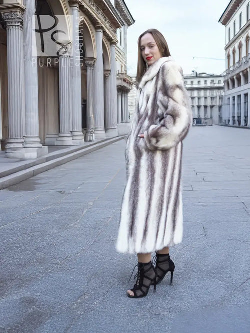 Hooded mink fur coat with flared silhouette, side view with hands at pockets