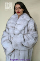 Light blue fox fur coat with plush texture and high collar, front close-up