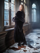 Black long hooded fur coat viewed from the side, open front with fur collar and full sleeves
