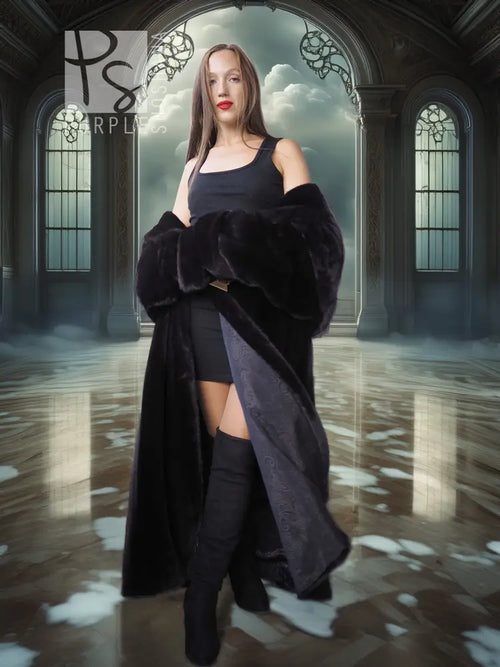 Black hooded long fur coat with wide sleeves and open front, worn over a short black dress