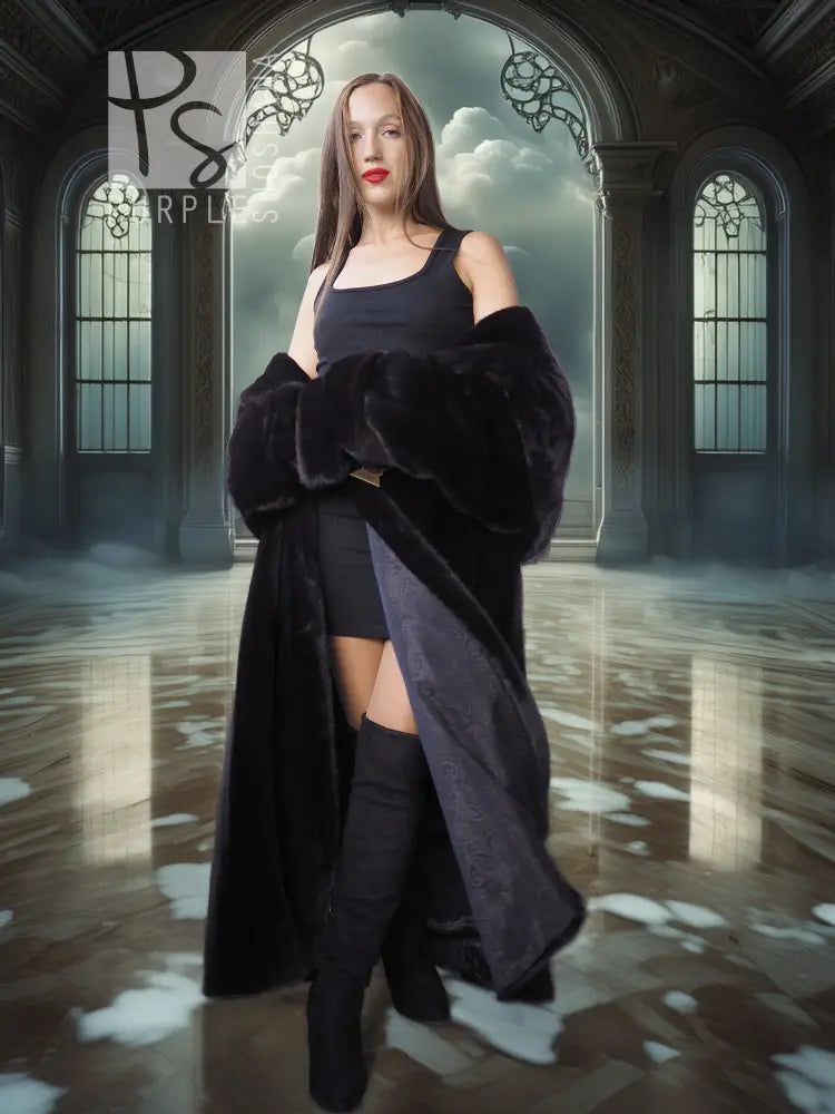 Black hooded long fur coat with wide sleeves and open front, worn over a short black dress