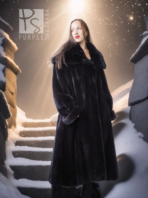Black hooded long mink coat with silk lining; standing view with draped sleeves.