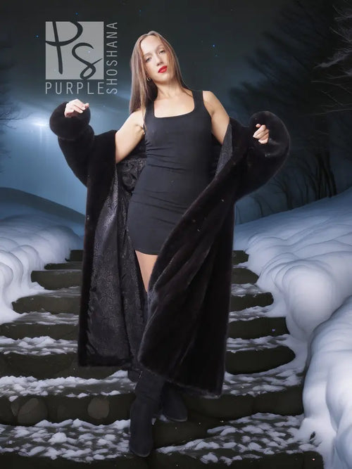 Black long hooded fur coat with open front and plush sleeves, worn over a short black dress