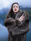 Long raccoon fur coat close-up with fuzzy collar and wide fur cuffs, dark gray tones