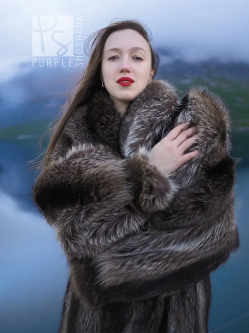 Long raccoon fur coat close-up with fuzzy collar and wide fur cuffs, dark gray tones