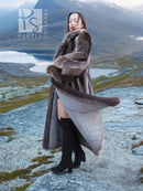 Long raccoon fur coat, dark gray, draped shoulders and flared sleeve cuffs over light dress