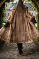 Back view of tan mink fur coat with hood and flared ribbed lower section