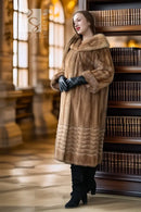 Tan mink fur coat with wide hood, long sleeves, and ribbed lower hem; black gloves