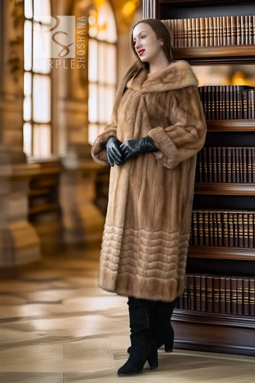 Tan mink fur coat with wide hood, long sleeves, and ribbed lower hem; black gloves