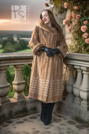 Tan mink fur coat with hooded collar and ribbed hem; black gloves and dark boots