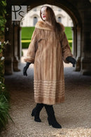 Tan mink fur long coat with hood and ribbed hem, seen full length with black boots