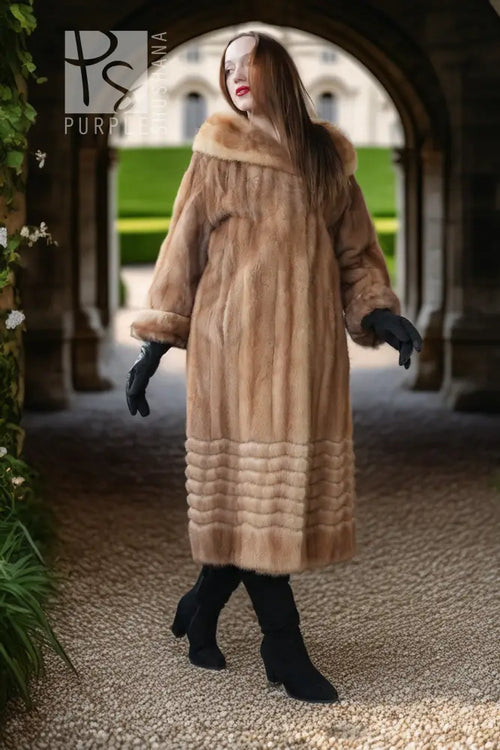 Tan mink fur long coat with hood and ribbed hem, seen full length with black boots