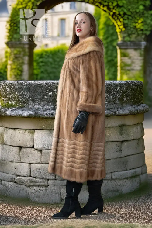 Tan mink fur coat with hooded collar and ribbed hem, styled with black gloves