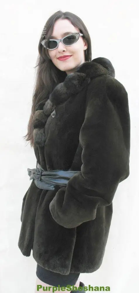 Women's dark fur coat with chinchilla pom-pom shoulder detail and belt
