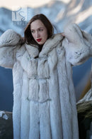 Light blue hooded faux fur coat with buttoned front and textured sleeve cuffs