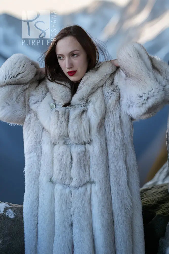 Light blue hooded faux fur coat with buttoned front and textured sleeve cuffs