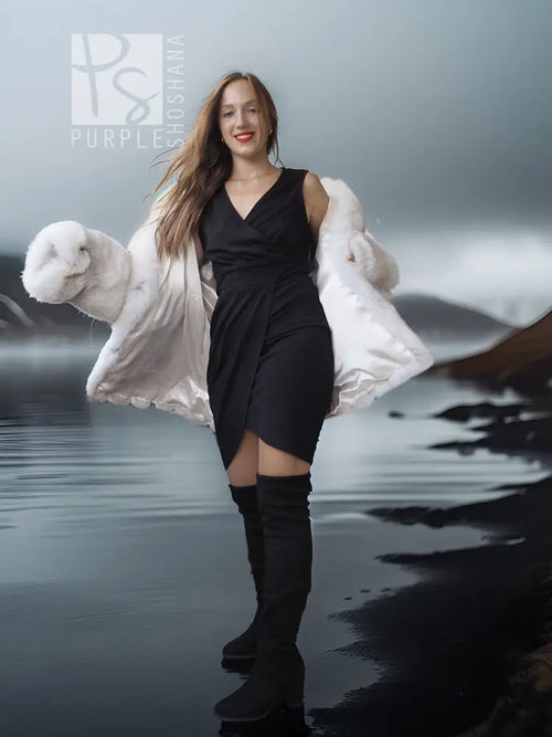 White faux fur shawl-collar coat over black dress, plush sleeve cuffs visible.