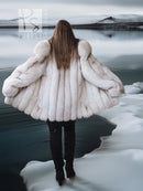 Back view of white faux fur coat with shawl collar and wide, voluminous sleeves.
