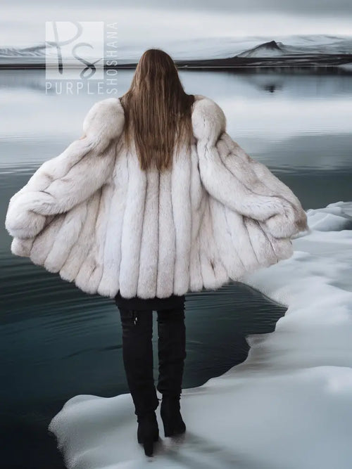 Back view of white faux fur coat with shawl collar and wide, voluminous sleeves.