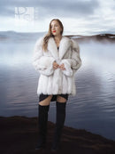 White faux fur coat with shawl collar, plush volume, front buttonless design.