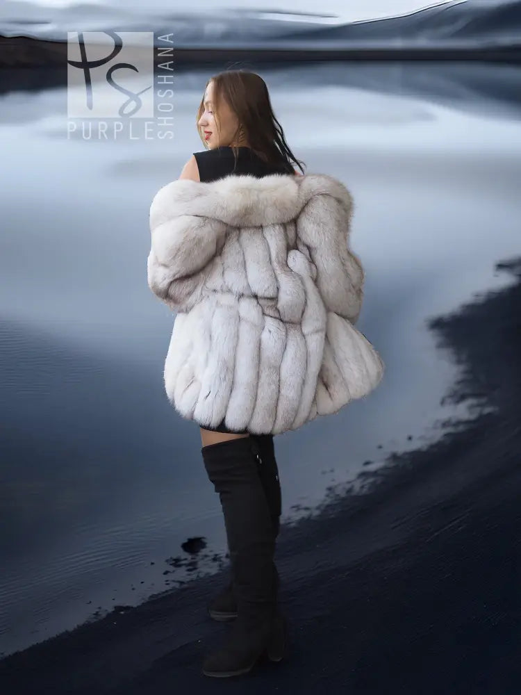 Side view of white faux fur coat with shawl collar, voluminous shoulders and sleeves.