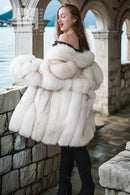 White plush fur jacket with voluminous layered sleeves and off-shoulder neckline