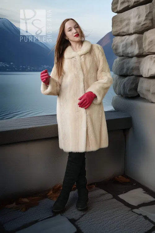 Ivory mink coat with flared hem and red gloves, long buttonless look