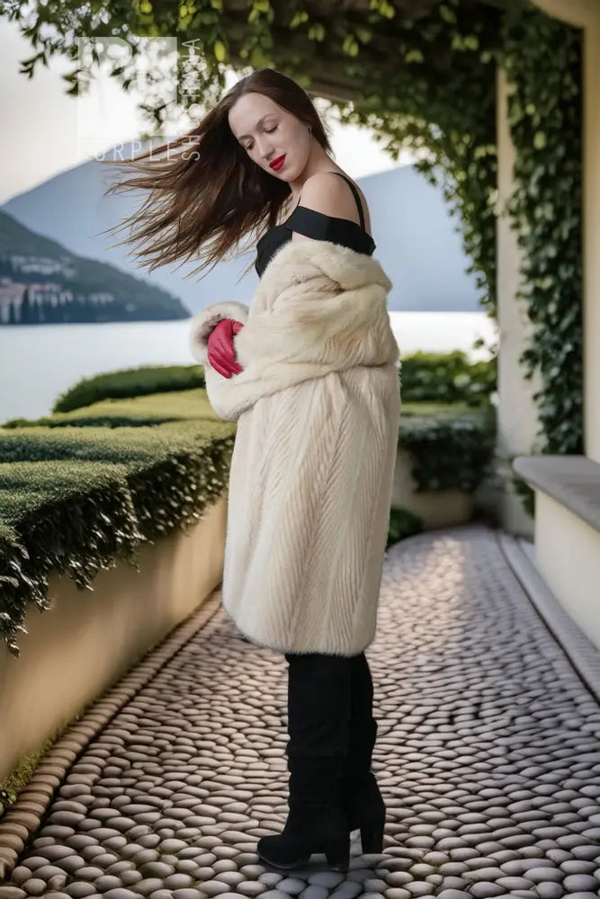 Ivory mink coat with raised collar and red gloves, long straight silhouette