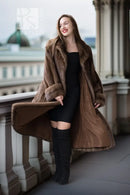 Women’s dark brown mink coat with hood, open front, and long sleeves over black outfit.