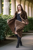 Women’s dark brown mink swing coat with hood, open front, and wide hem detail.