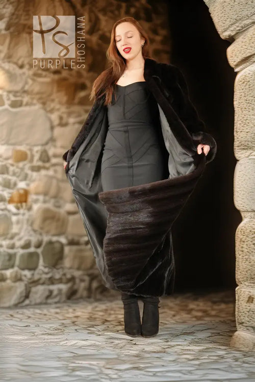 Open black mink coat showing gray satin lining drape, long sleeves.