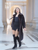 Long mink fur coat with tie belt and wide collar, open front showing dress and boots