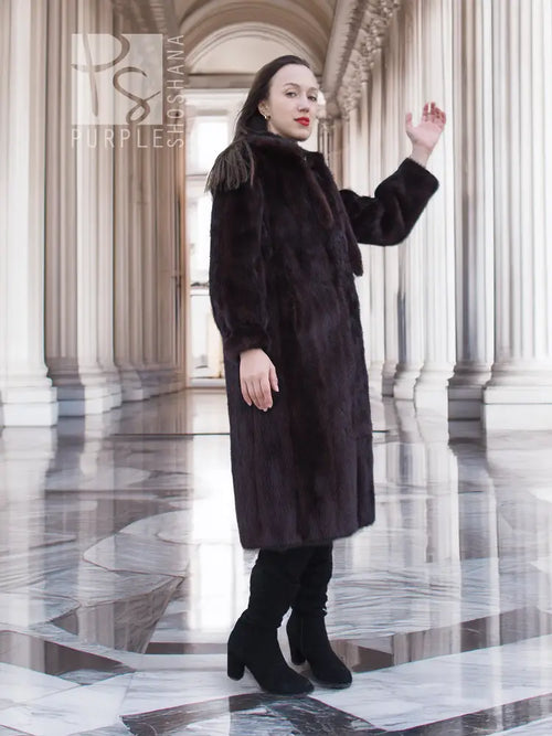 Dark mink fur coat with tie waist, long sleeves, mid-calf hem.