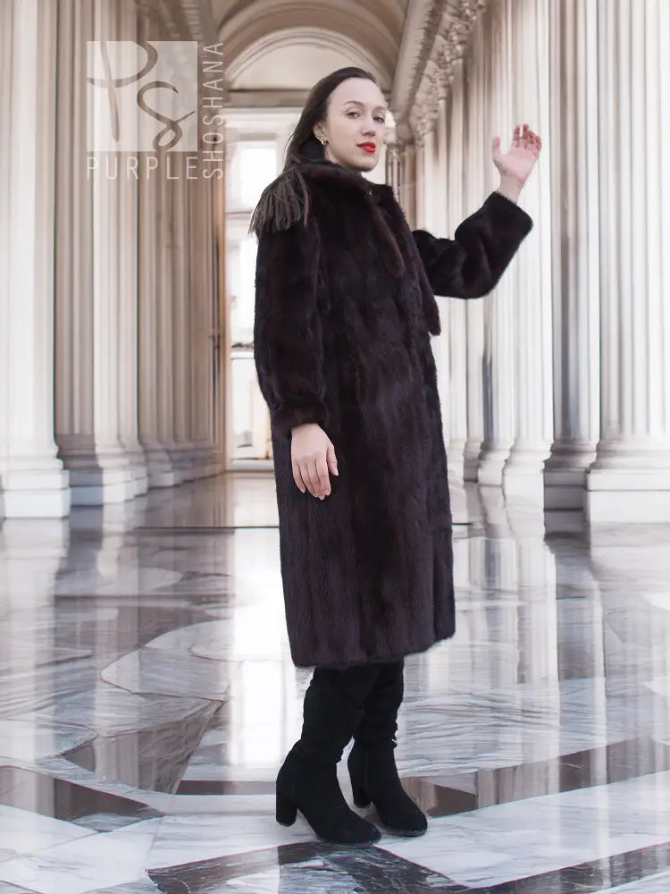 Dark mink fur coat with tie waist, long sleeves, mid-calf hem.