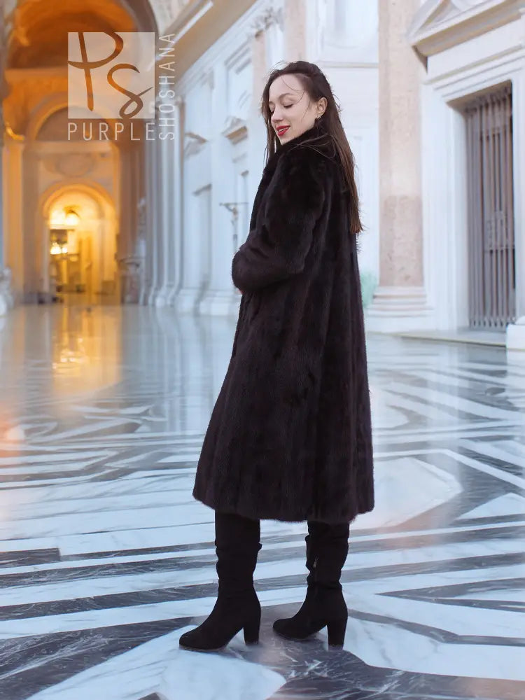 Dark mink fur coat with tie closure, mid-calf length, long sleeves.