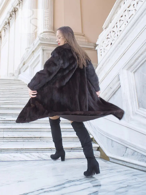 Mink fur coat with tie belt, flowing long hem and wide collar, side view