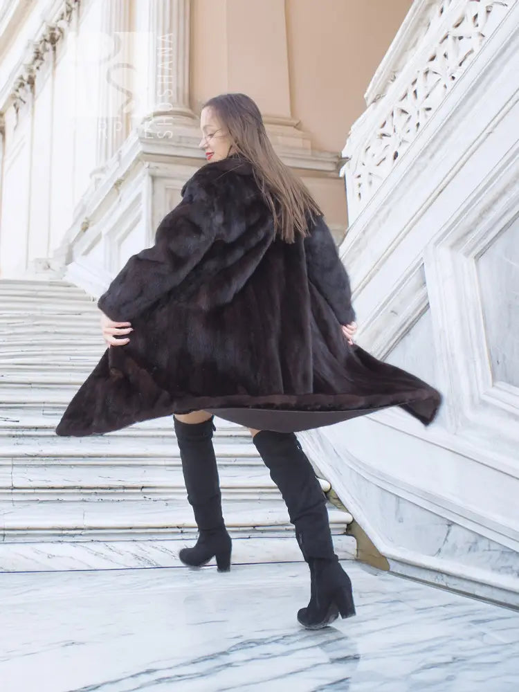 Mink fur coat with tie belt, flowing long hem and wide collar, side view