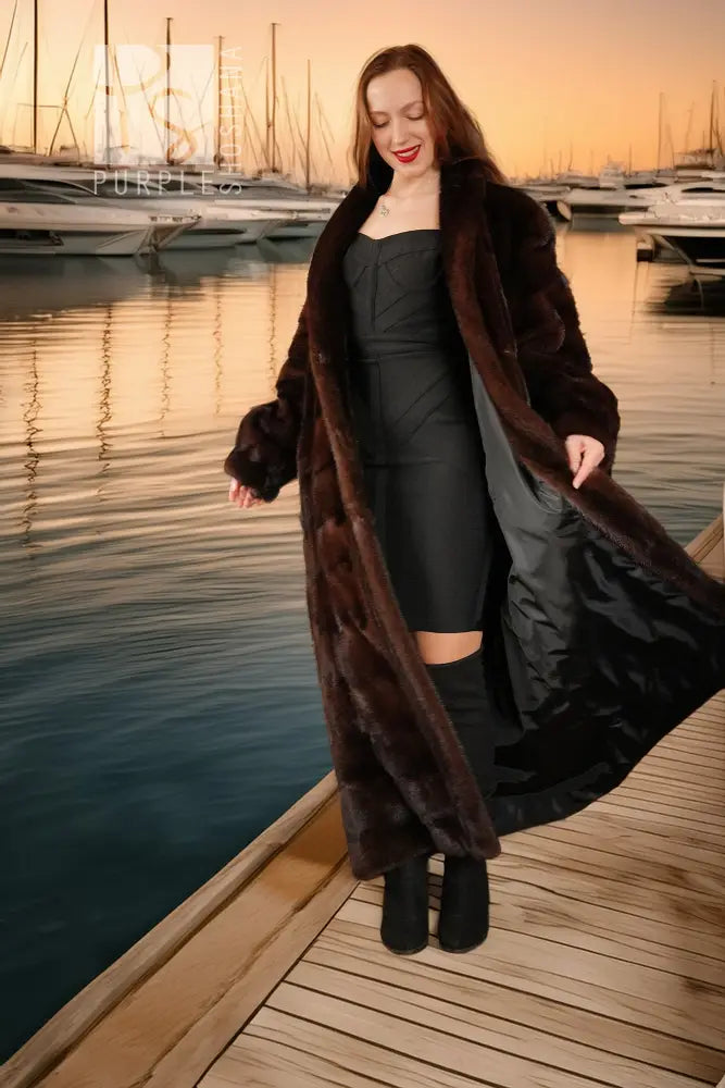 Dark brown reversible mink coat with black dress underneath, open front and long hem.