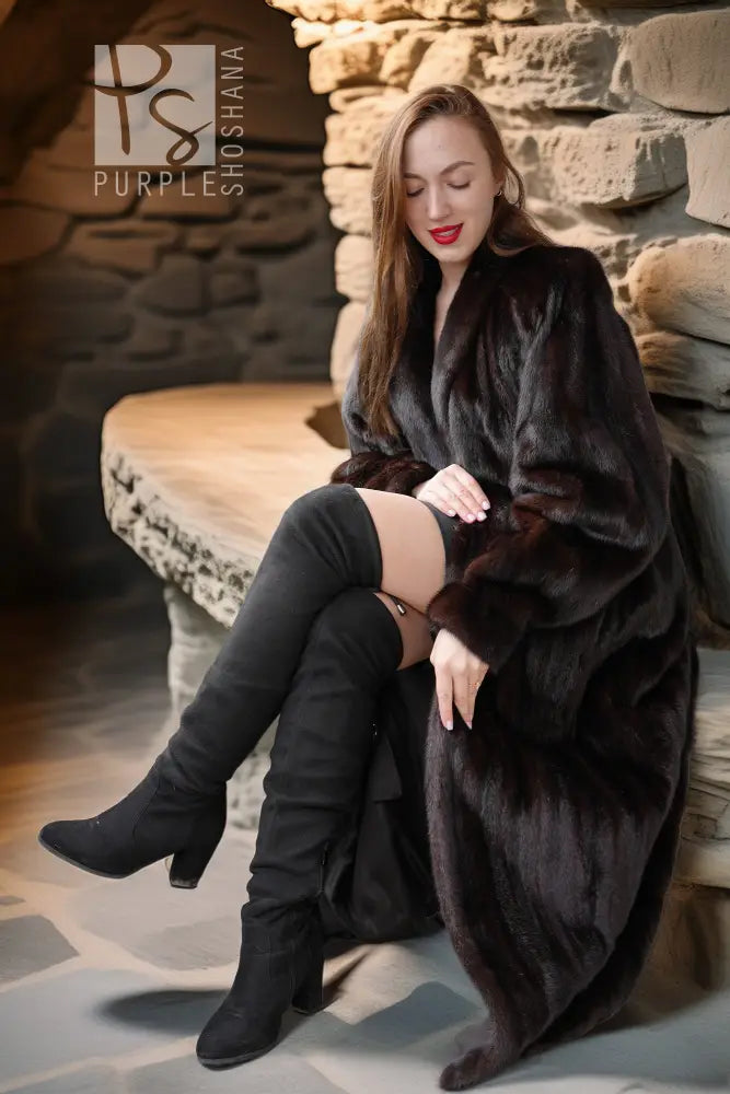 Black mink coat on seated pose, wide sleeves, dark fur trim and long length